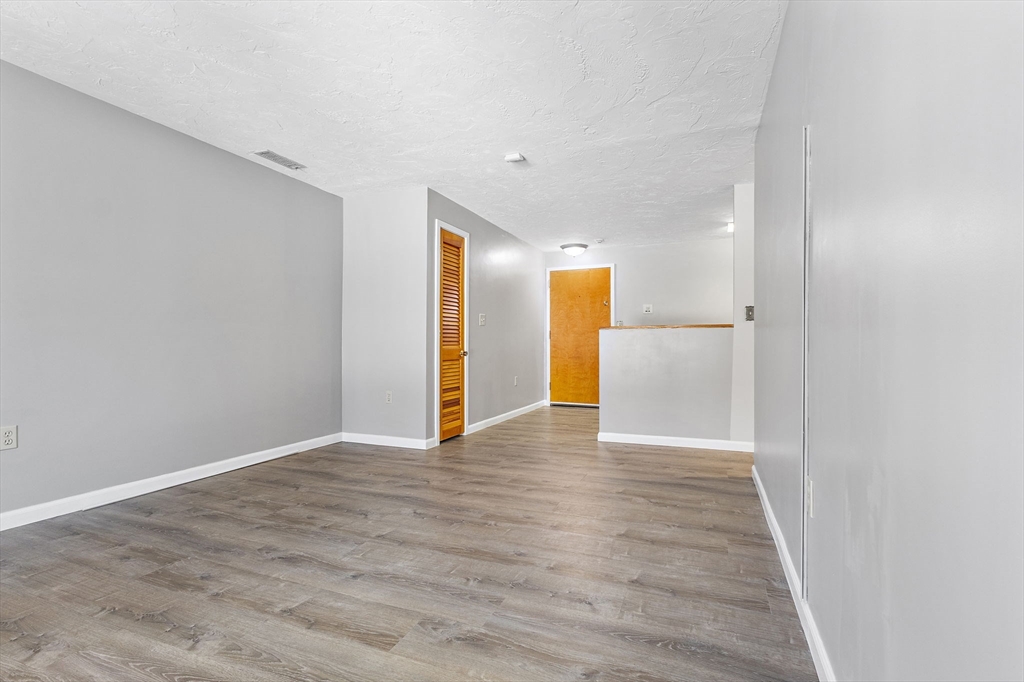 189 Littleton Road, Unit 10 Chelmsford, MA 01824 - Photo 8 of 19 a view of an empty room with wooden floor and closet