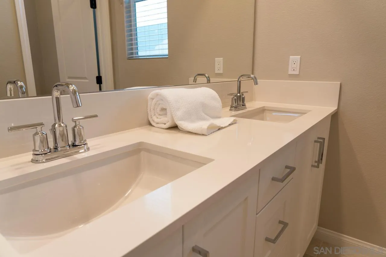 1790 Whitmore Loop Chula Vista, CA 91913 - Photo 18 of 28 a bathroom with a granite countertop sink and a mirror