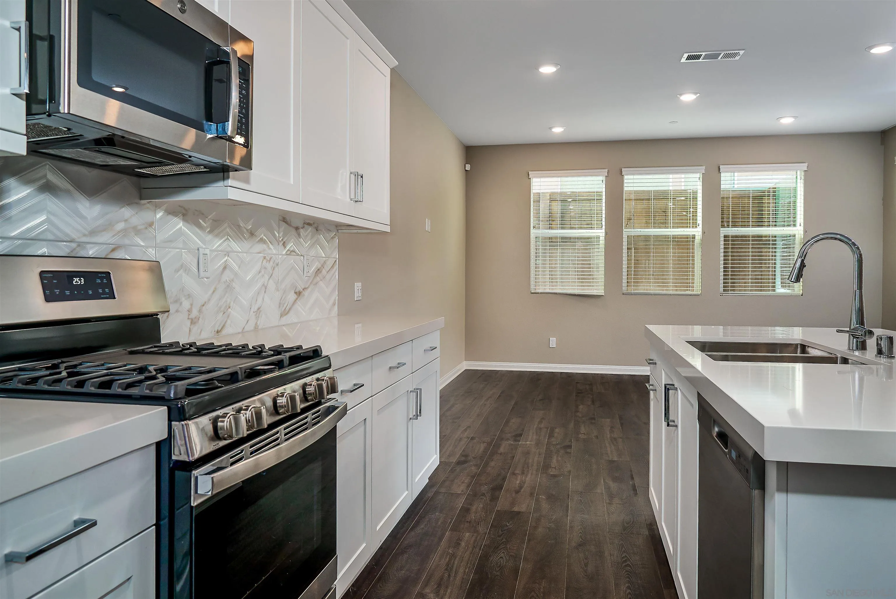 1790 Whitmore Loop Chula Vista, CA 91913 - Photo 27 of 28 a kitchen with stainless steel appliances granite countertop a stove a sink and a microwave
