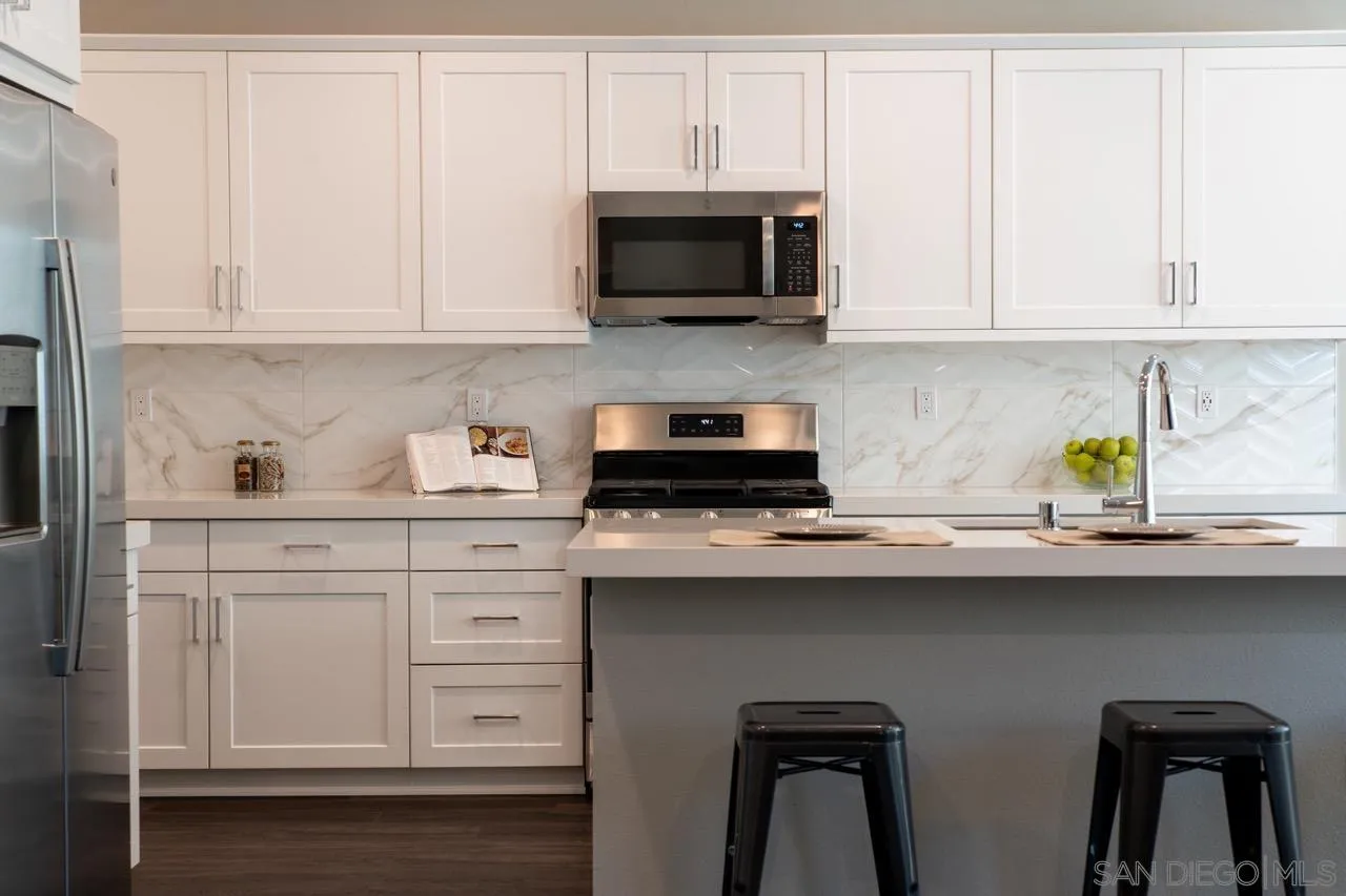 1790 Whitmore Loop Chula Vista, CA 91913 - Photo 4 of 28 a kitchen with stainless steel appliances white cabinets and a sink