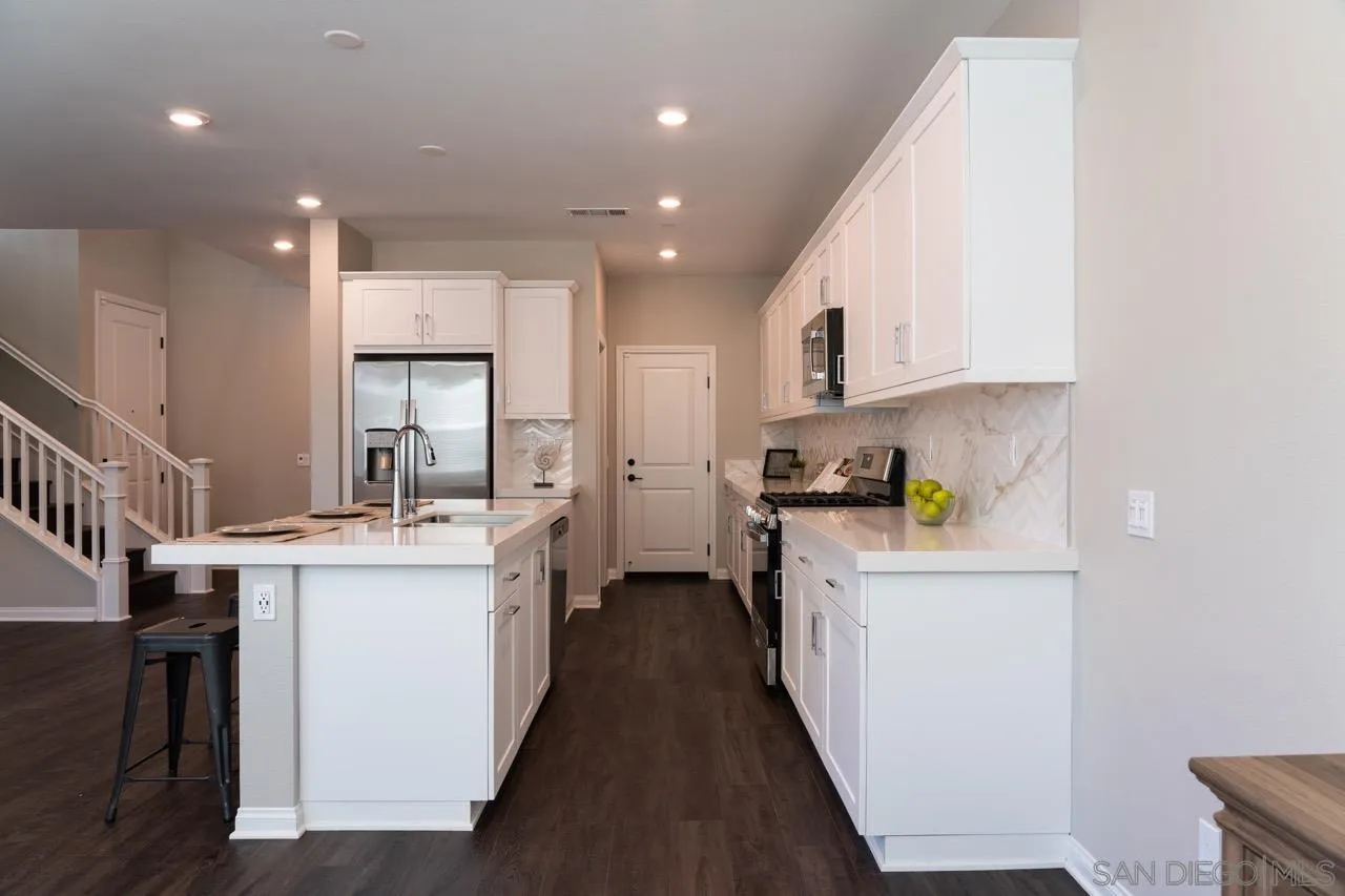 1790 Whitmore Loop Chula Vista, CA 91913 - Photo 5 of 28 a kitchen with kitchen island a sink stove and cabinets