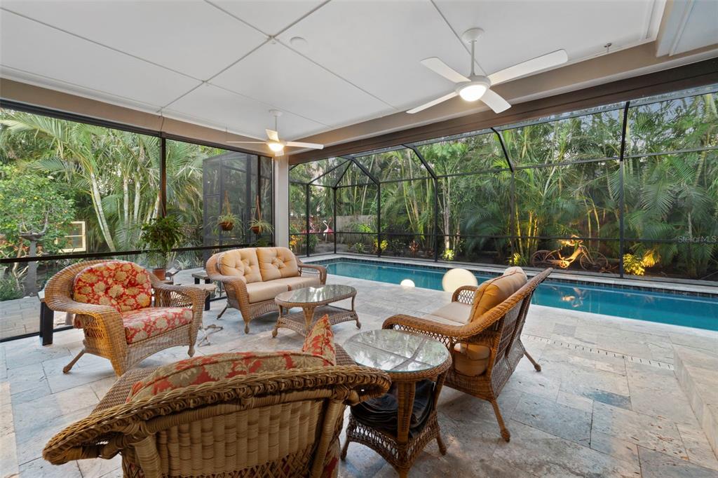 a living room with patio furniture and a floor to ceiling window