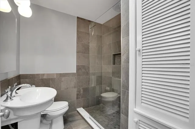 a bathroom with a sink a toilet and shower