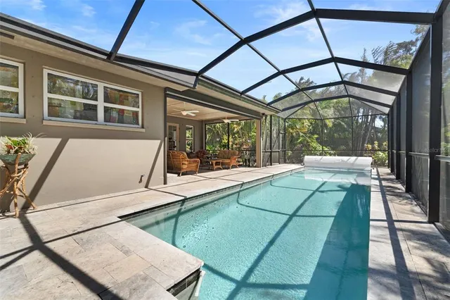 a living room with patio furniture and a floor to ceiling window