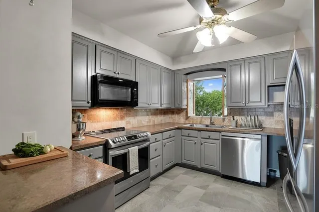 a kitchen with stainless steel appliances granite countertop a sink stove and refrigerator