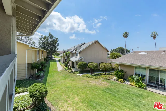 a view of a house with a yard and potted plants