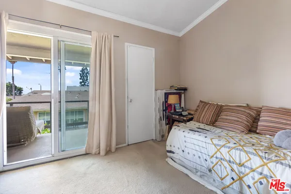 a bedroom with a bed and glass door