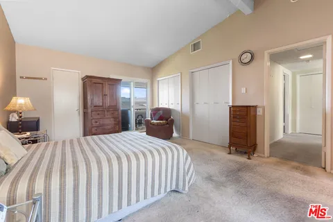 a bedroom with a bed and a large mirror