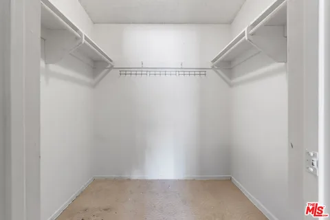 a spacious bedroom with a bed and a lamp