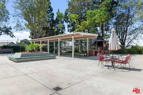 a view of a patio with a table and chairs under an umbrella