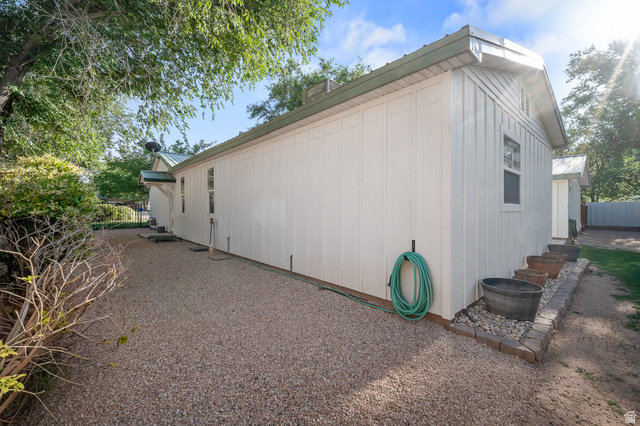 236 West 300 South Hurricane, UT 84737 - Photo 69 of 76 Property exterior featuring vertical board siding, a metal roof, and a gravel ground cover