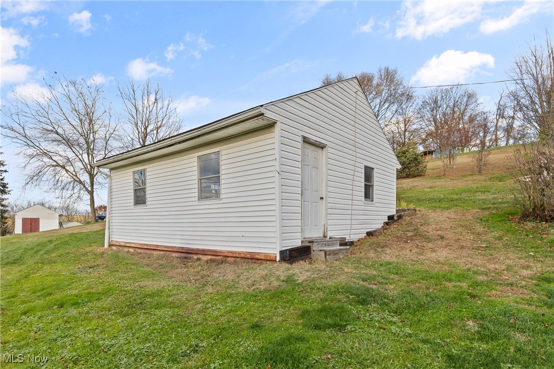 102 Potrock Road Wellsburg, WV 26070 - Photo 33 of 42 View of home's exterior with a lawn and an outbuilding