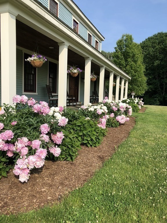 339 Stow Road Harvard, MA 01451 - Photo 4 of 40 a front view of a house with lots of flower and trees