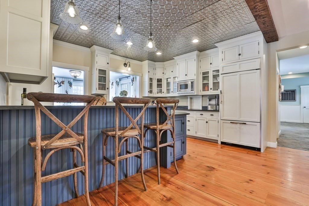 339 Stow Road Harvard, MA 01451 - Photo 9 of 40 a kitchen with stainless steel appliances kitchen island granite countertop a table chairs and a refrigerator