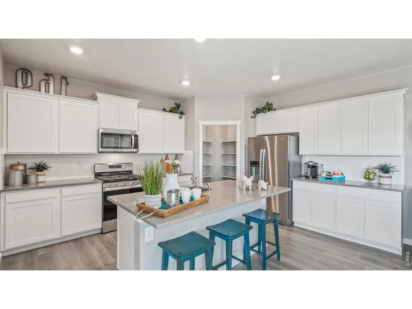 a kitchen with appliances a sink and cabinets