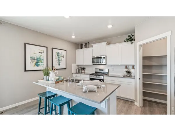 a kitchen with kitchen island a stove a table and chairs