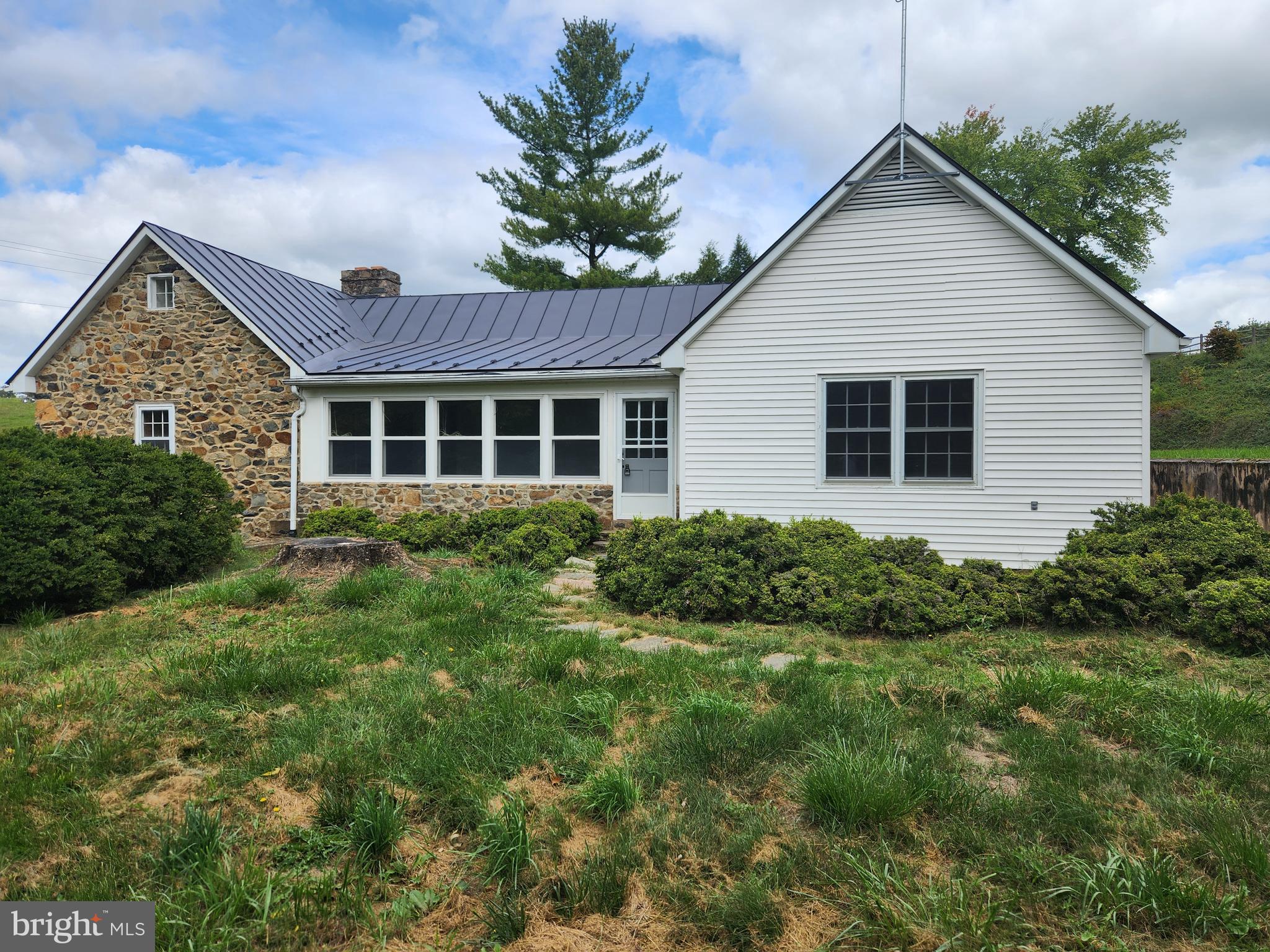 a view of house with a yard and potted plants
