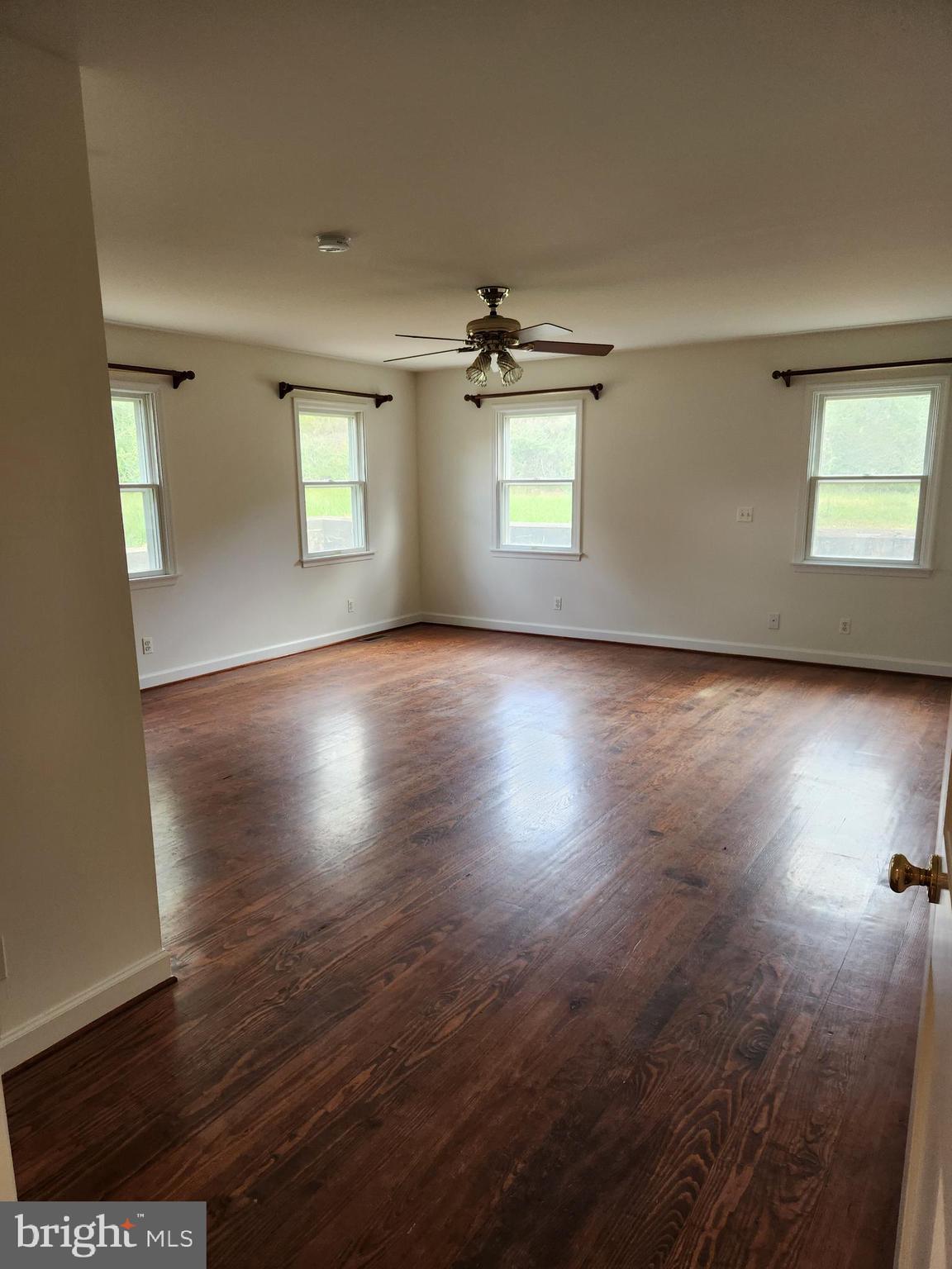 2000 Rectortown Road Delaplane, VA 20144 - Photo 12 of 16 an empty room with wooden floor chandelier and windows