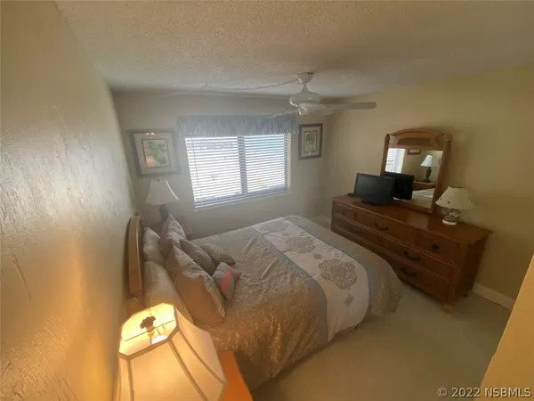 a bedroom with a bed and mirror
