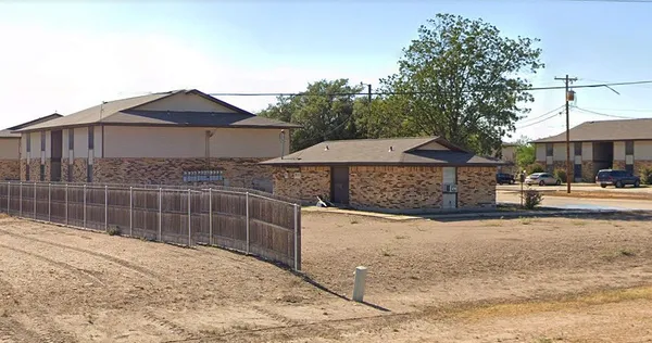 a view of a street with a wooden fence