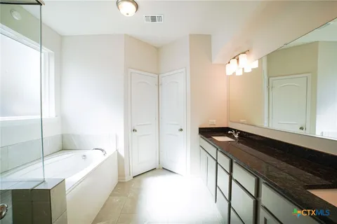a bathroom with a granite countertop sink a toilet and shower