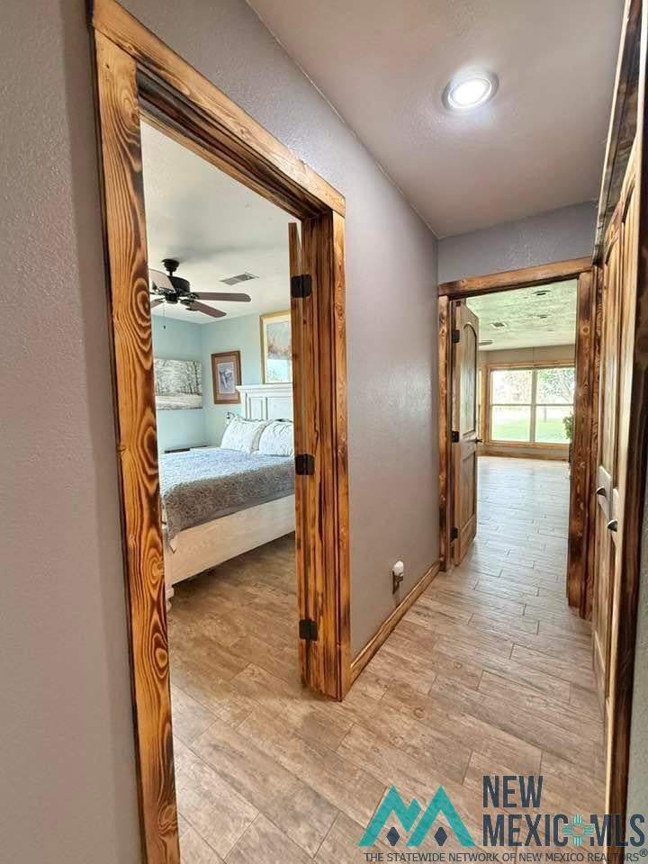 5404 Sioux Road Carlsbad, NM 88220 - Photo 46 of 100 Hallway featuring wood-finish flooring, recessed lighting, and natural wood door frames