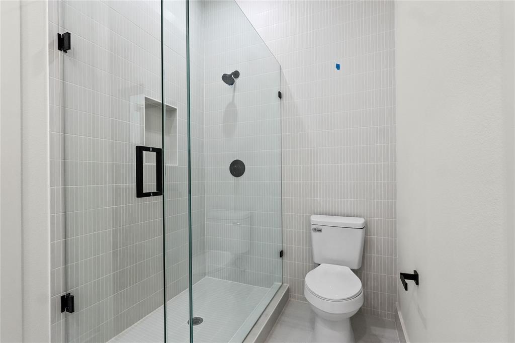 2031 North Prairie Avenue, Unit 101 Dallas, TX 75204 - Photo 18 of 23 Bathroom featuring a shower stall and tile walls