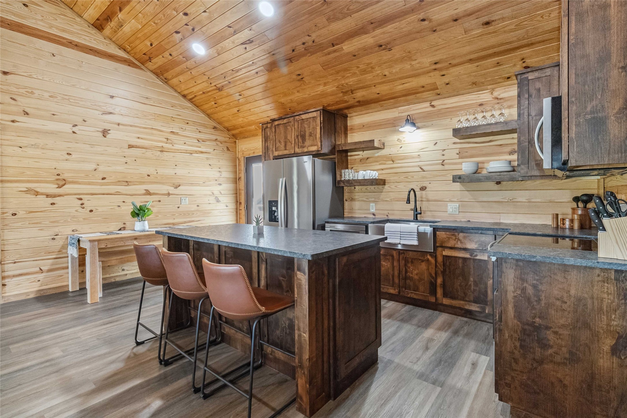 Kitchen featuring a sink, open shelves, dark countertops, appliances with stainless steel finishes, and wood ceiling