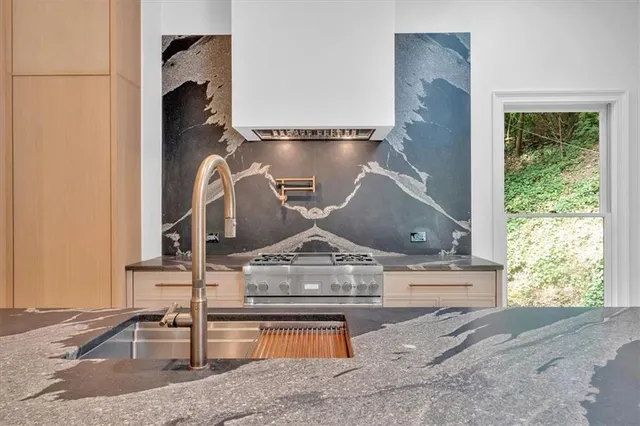 a front view of a house with a garden and trees