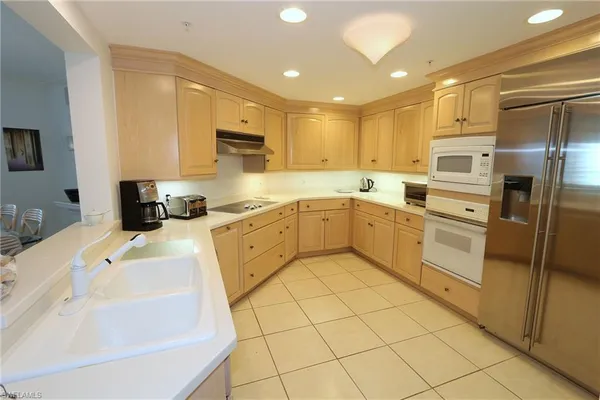 a kitchen with white cabinets and appliances