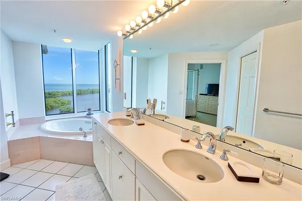 a spacious bathroom with a double vanity sink mirror and bathtub