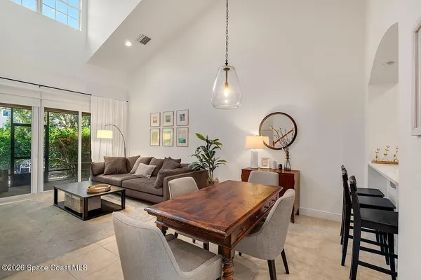 a living room with furniture a chandelier and a floor to ceiling window