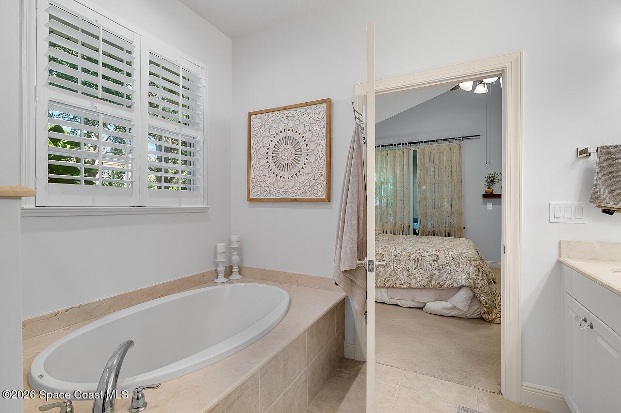 1629 Baseline Lane Vero Beach, FL 32967 - Photo 14 of 29 a bathroom with a tub a sink and a mirror