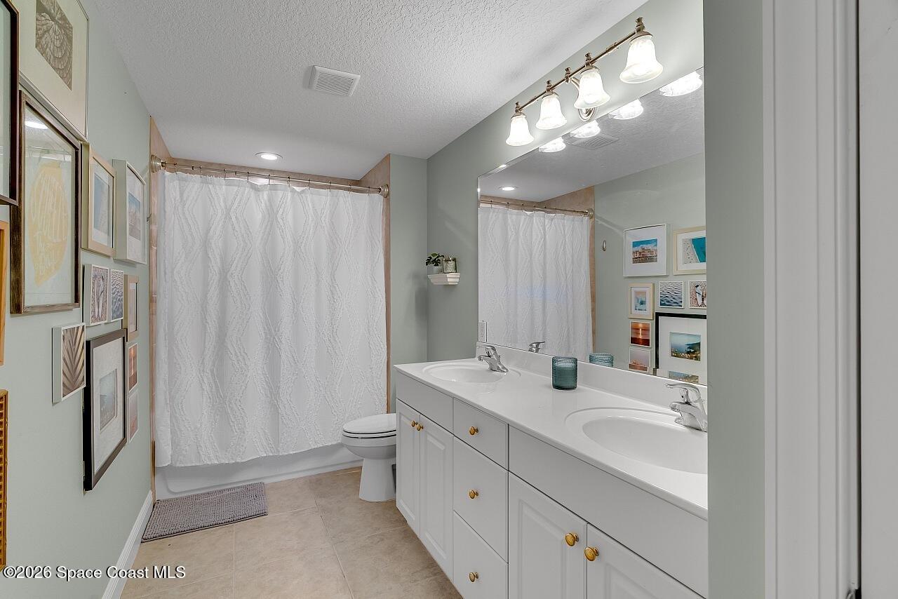 1629 Baseline Lane Vero Beach, FL 32967 - Photo 20 of 29 a bathroom with double vanity sink a toilet and a mirror