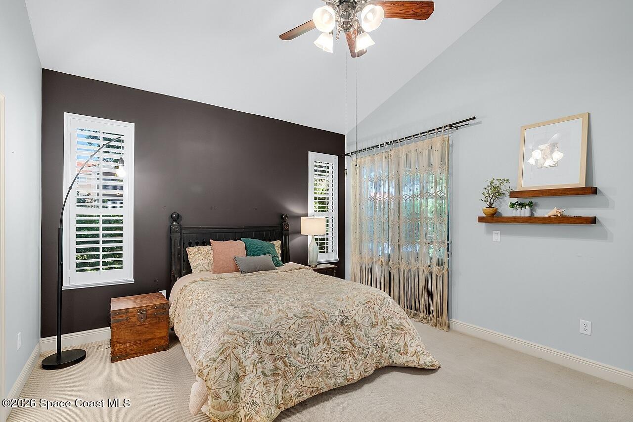 1629 Baseline Lane Vero Beach, FL 32967 - Photo 10 of 29 a bedroom with a large bed and a chandelier