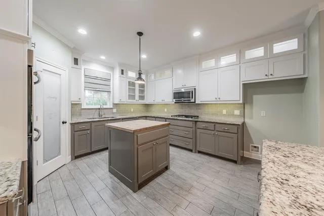 a large kitchen with cabinets wooden floor and stainless steel appliances