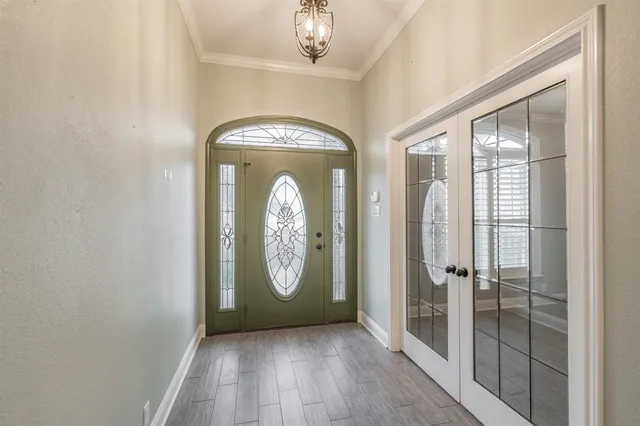 a view of a hallway with wooden floor and a kitchen
