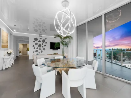 a dining room with furniture a kitchen and chandelier