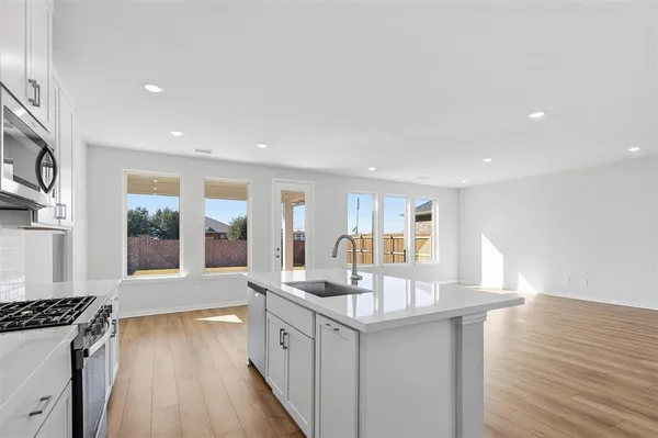 a kitchen with stainless steel appliances granite countertop a sink stove and wooden floor
