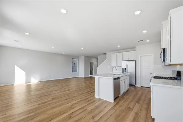 a kitchen with stainless steel appliances kitchen island granite countertop a stove a sink a refrigerator and cabinets