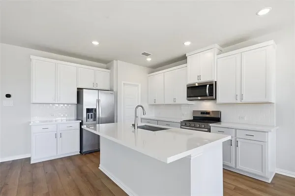 a kitchen with white cabinets stainless steel appliances and sink