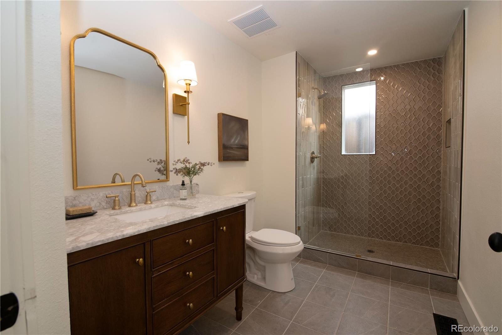 2831 Perry Street Denver, CO 80212 - Photo 13 of 29 a bathroom with a double vanity sink a toilet and a mirror