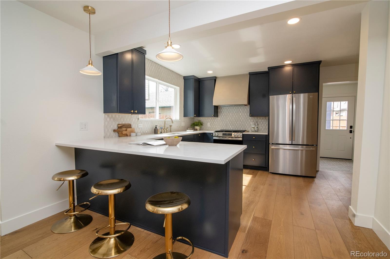 2831 Perry Street Denver, CO 80212 - Photo 7 of 29 a kitchen with stainless steel appliances a sink a stove a refrigerator and chairs