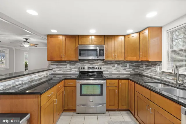 a kitchen with stainless steel appliances granite countertop a sink stove and cabinets
