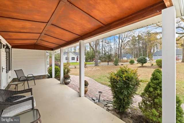 a view of a patio with table and chairs and floor to ceiling window