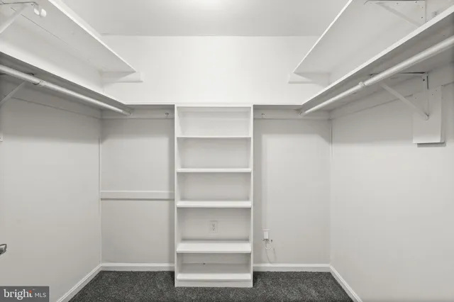 a view of walk in closet with empty racks