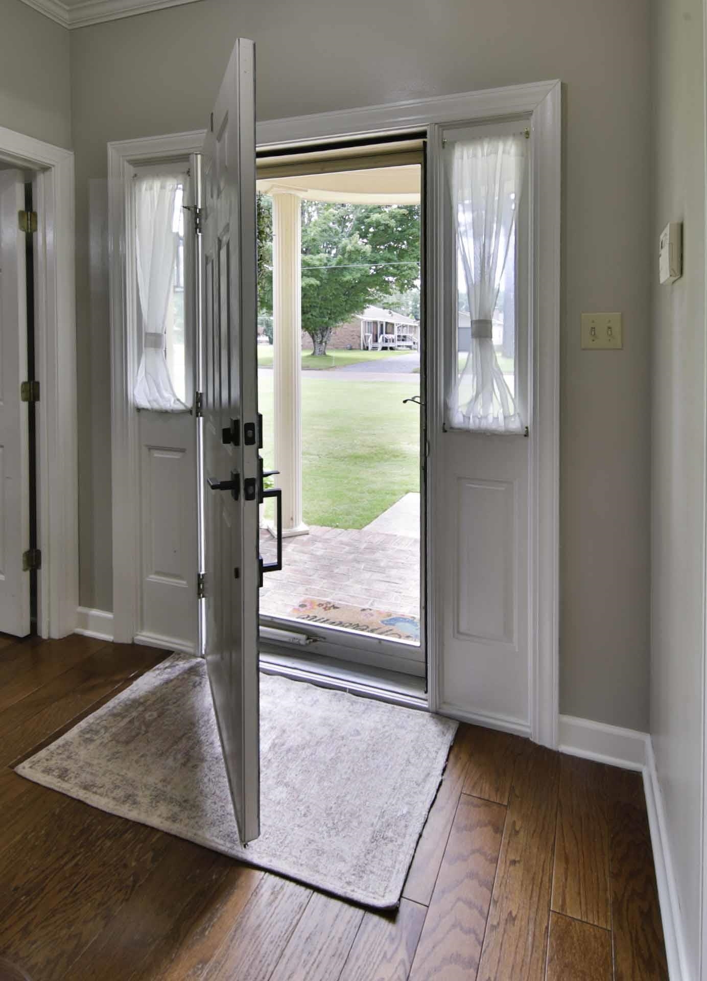 104 Miller Road Covington, TN 38019 - Photo 10 of 25 Entryway featuring wood-finish flooring, a paneled door with dark hardware, and side light windows