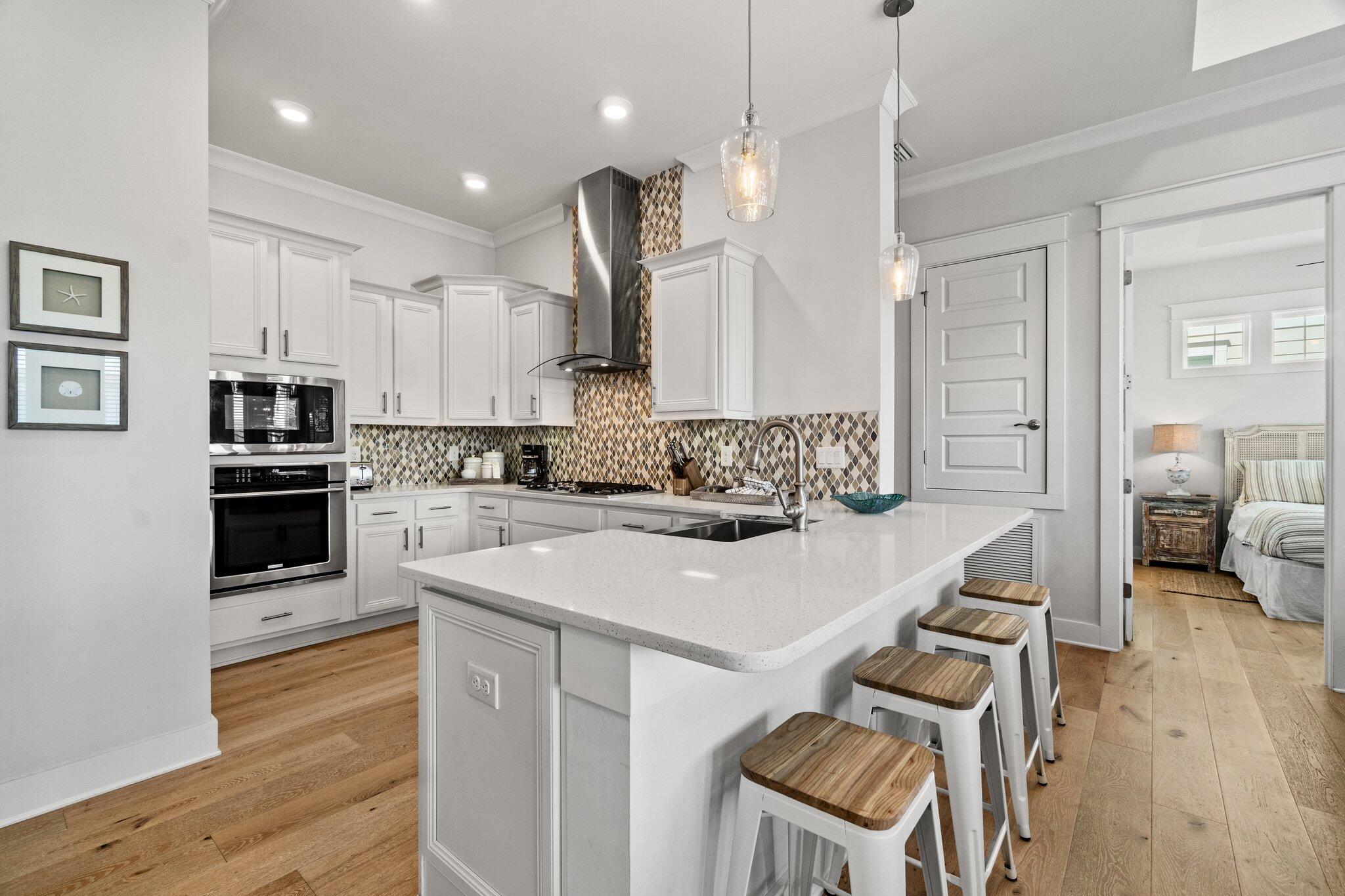 89 Pine Lands Loop Inlet Beach, Unit C Inlet Beach, FL 32461 - Photo 7 of 65 a large kitchen with kitchen island a stove a sink a center island and wooden floor