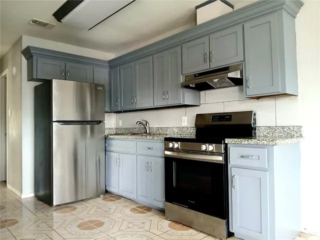 a kitchen with stainless steel appliances granite countertop a refrigerator stove a sink and dishwasher