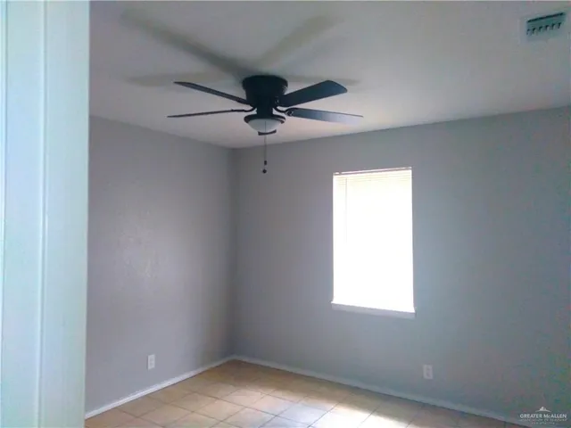 an empty room with a window and a fan
